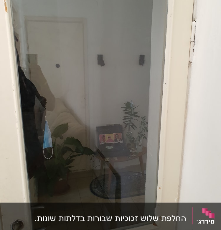 דלת זכוכית עם השתקפות של פנים חדר